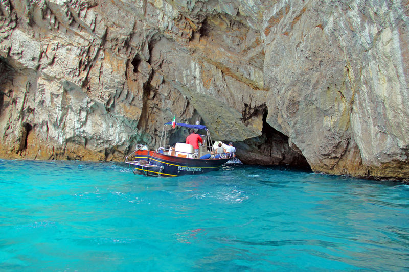 Rejs wokół wyspy Capri - łódka wpływająca do niewielkiej groty