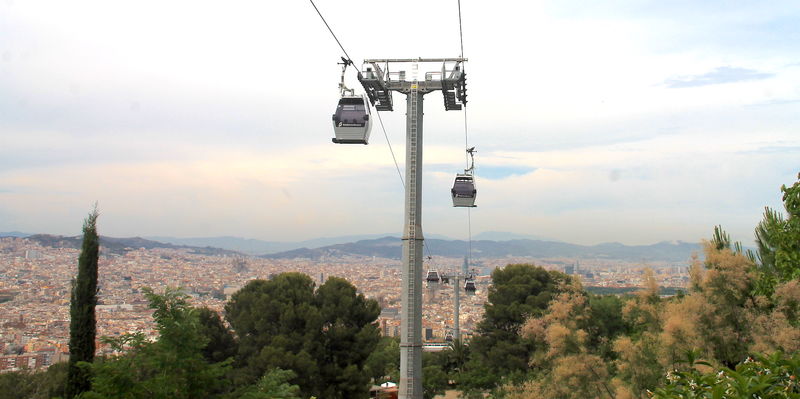 Widok na kolejkę szynową Teleferic de Montjuïc wjeżdżającą w okolice zamku na wzgórzu Montjuïc w Barcelonie