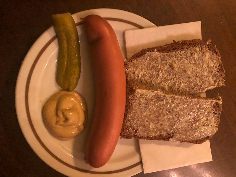 !Na zdjęciu Bockwurst serwowany z musztardą, ogórkiem i chlebem w jednym z pubów